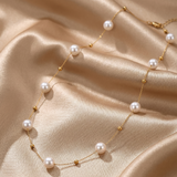 Pearl necklace with gold accents on a beige fabric background